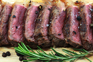Medium Beef Rib Eye steak slices on wooden board