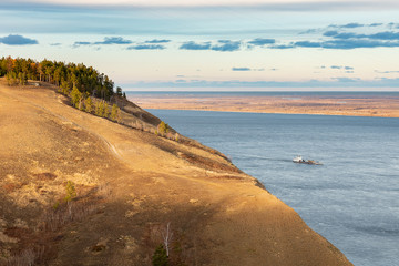 Yakutian landscape with the great Lena River at gold sunset. Beautiful view on the Tabaginsky cape. River navigation in Yakutia