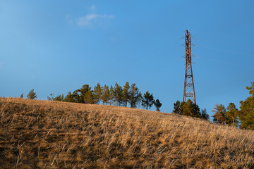 Power lines on the hill Tabaginsky Cape in Yakutia during the golden sunset. Autumn landscape