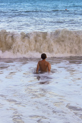 The boy frolics in the big waves