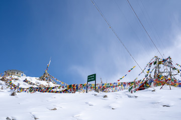 Tibetan prayer flag at Khardung La in winter. Khardung La is a mountain pass in the Ladakh region...