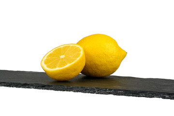 Fresh yellowe lemons on stone cutting board isolated on white background - image