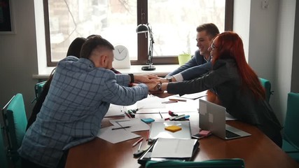Business concept. A smiling working team at the conference putting their hands together