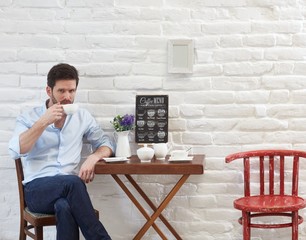 Young man drinking in cafe