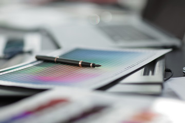 blurred image of a blueprint and a pen on the designer's Desk