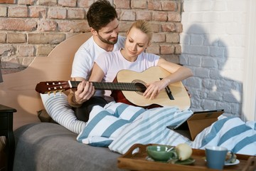 Romantic couple playing the guitar together