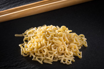 haufen roher Buchstabennudeln und Essstäbchen