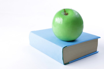 close up.book and green Apple on white background