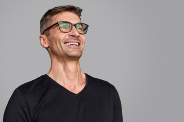 Obraz premium Roześmiany facet w okularach, odwracając wzrok