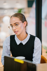 A wonderful Caucasian woman taking a gander at her colleague. She is wearing a decent corporate dress with a costly watch and eyeglasses.