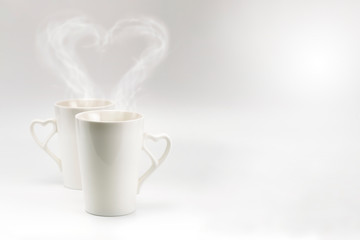 A couple white cup with heart steam and heart handle in horizontal format