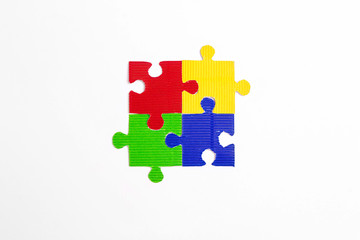 Four colored puzzle pieces on a white background. Autism Awareness Day.