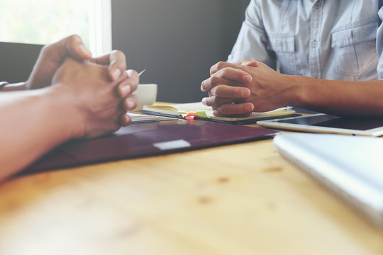 The hands of two men on a wooden table.Negotiation concept Or job interview