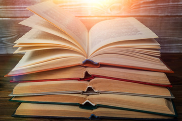 A stack of open books against a wooden table. education, reading, bookkeeping.