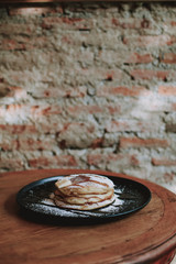 pancake with icing and butter on wooden table