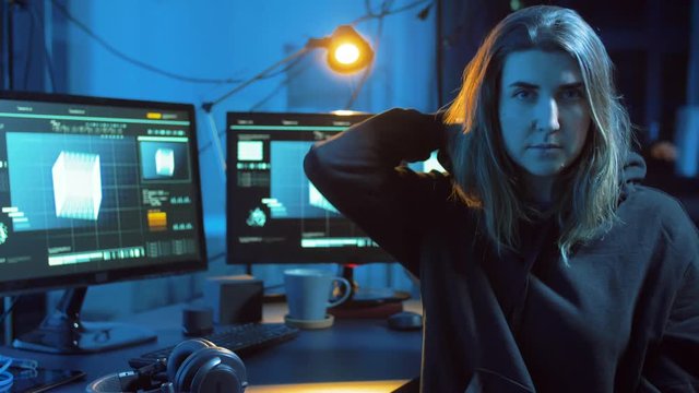 cybercrime, hacking and technology concept - female hacker in dark room creating code or using computer virus program for cyber attack
