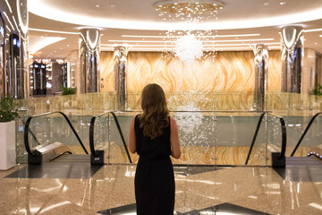 Junge Frau steht in einer Luxus Gallerie in Abu Dhabi