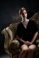 Elegant young woman sitting on sofa