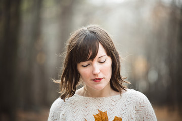 Woman Holding a maple Leaf in autumn