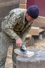 white guy joiner carpenter handles grinder wooden detail