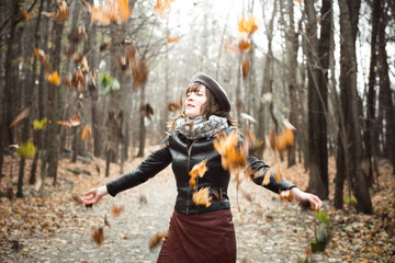 Woman throwing dry leaves in the air