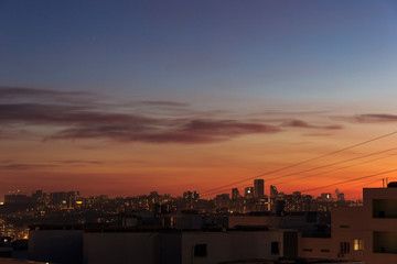City downtown Sunset.City skyline in the dusk. Amazing panoramic view of modern city.Construction site with cranes on new residential areas