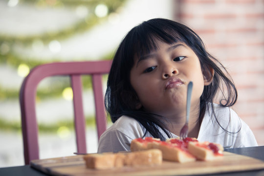 cute baby eating boring food,Asian  baby bored looking face looking at her breakfast,Children with bread