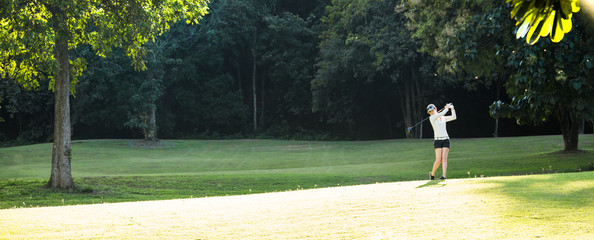 Asian woman playing golf on a beautiful natural golf course