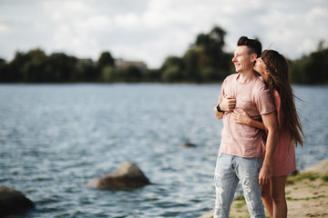 Loving young couple kissing and hugging in outdoors. Love and tenderness, dating, romance, family, anniversary concept.