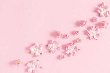 Fototapeta na wymiar Flowers composition creative. Pink flowers on pastel pink background. Flat lay, top view, copy space