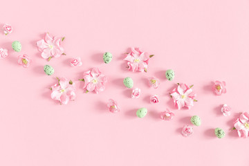 Easter pink composition. Flowers, easter eggs on pastel pink background. Flat lay, top view, copy space