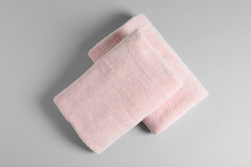 Soft folded towels on light background, top view