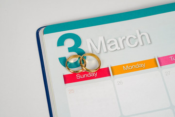 Gold Wedding ring on calendar planning or office tool.