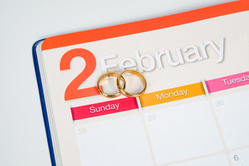 Gold Wedding ring on calendar planning or office tool.