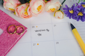 Word Wedding to Reminder Wedding day with Wedding ring on calendar planning and office tool.