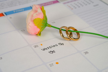 Word Wedding to Reminder Wedding day with Wedding ring on calendar planning and office tool.