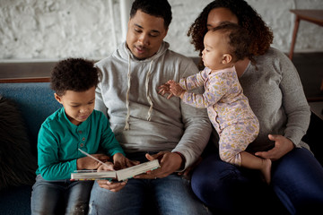 High angle view of parents with children relaxing on sofa at home