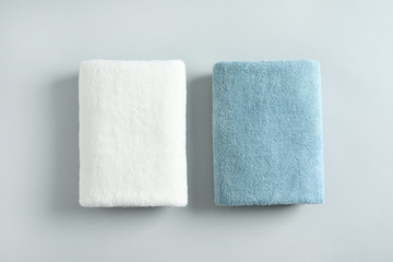 Fresh fluffy folded towels on grey background, top view. Mockup for design - obrazy, fototapety, plakaty