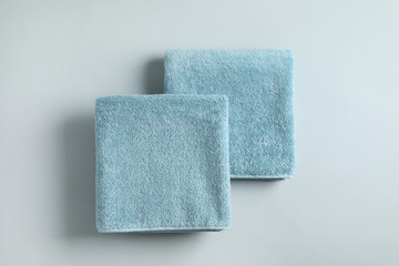 Fresh fluffy folded towels on grey background, top view. Mockup for design