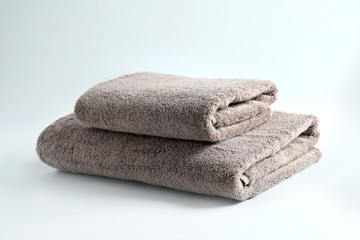 Stack of fresh fluffy towels on grey background