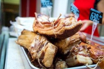 Big pile of whole bacon. Big smoked bacon. Pieces of smoked bacon large in the store