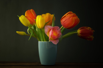beautiful tulips in vase on green background