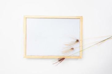 white board with grass flowers on white background with space for your ideas texts. top view.