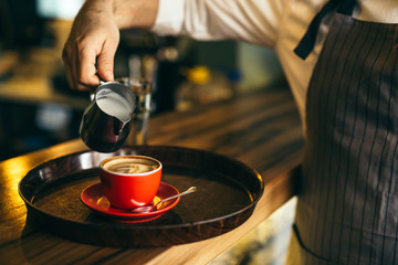 Fototapeta na wymiar closeup of barman pouring milk into espresso coffee