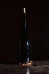 Fototapeta na wymiar Wine bottle with wineglass in black background.