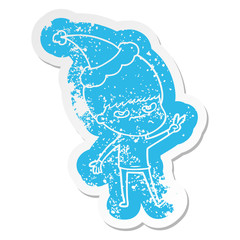 annoyed cartoon distressed sticker of a boy wearing santa hat