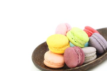 Fototapeta na wymiar Close up many colorful fresh macarons pile isolated in wood ladle on white background, look delicious, have copy space