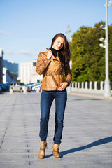 Young happy woman in brown leather jacket