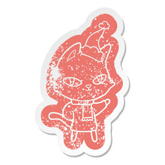 cartoon distressed sticker of a cat staring wearing santa hat