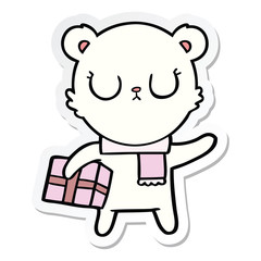 sticker of a peaceful cartoon polar bear with christmas gift